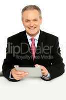 Handsome aged business male using tablet pc