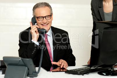 Aged businessman communicating on phone