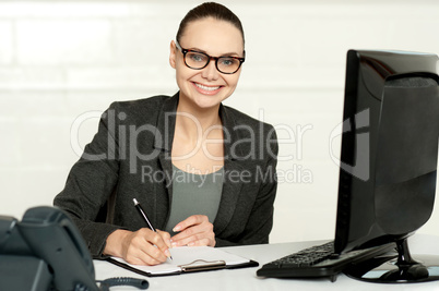 Female executive writing on notepad