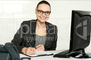 Female executive writing on notepad