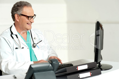 Experienced doctor working on computer