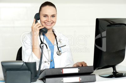 Young smiling physician sitting in clinic