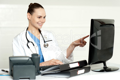 Female medical expert pointing at computer screen