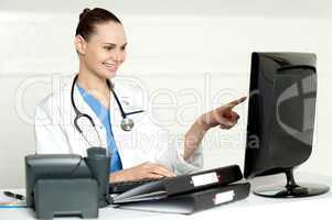 Female medical expert pointing at computer screen