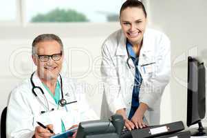 Doctors team. Female assistant typing on keyboard