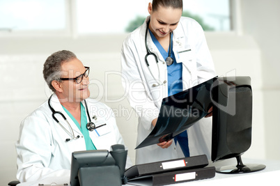 Team of two doctors reviewing x-ray report