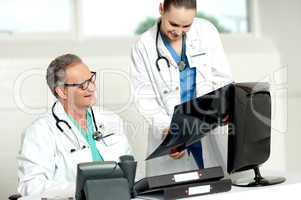 Team of two doctors reviewing x-ray report