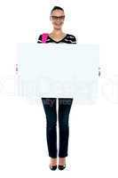 College girl holding white ad board, full length shot