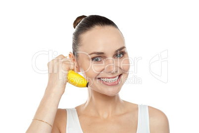 Girl doing call gesture using banana as cellphone
