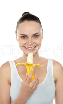 Cheerful fit woman eating banana