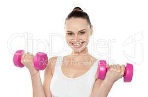 Attractive athlete exercising with dumbbells