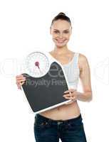 Healthy young woman with a weighing scale