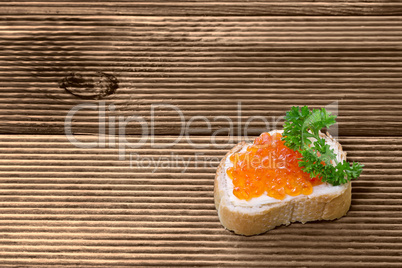 Sandwiches with red caviar  on wooden plank