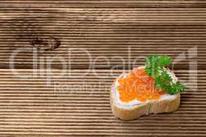 Sandwiches with red caviar  on wooden plank
