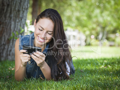 Mixed Race Young Female Texting on Cell Phone Outside