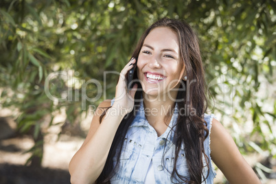 Mixed Race Young Female Talking on Cell Phone Outside