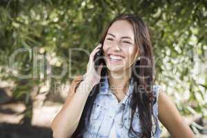 Mixed Race Young Female Talking on Cell Phone Outside