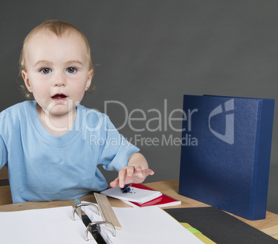 child with paperwork at small desk