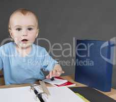 child with paperwork at small desk