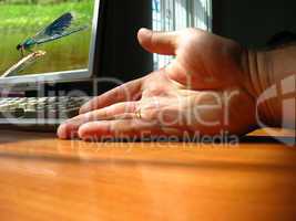 The hand of the person near a computer