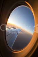 Looking through airplane window at sunset