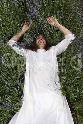 Happy young man relaxing in a field of lavender