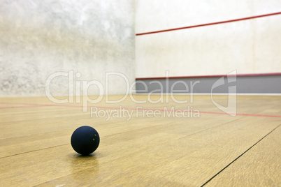 Squash court with pro ball lying on the floor