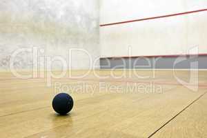 Squash court with pro ball lying on the floor