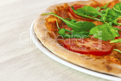 Pizza Margharita with arugula and slices of tomato