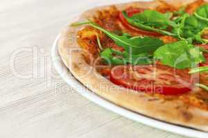 Pizza Margharita with arugula and slices of tomato