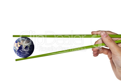Blue planet earth between green chopsticks