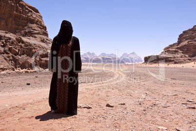 Nomadic woman with burka in the desert