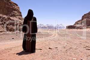 Nomadic woman with burka in the desert