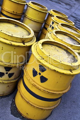 Radioactive warning symbol on yellow tuns of toxic waste