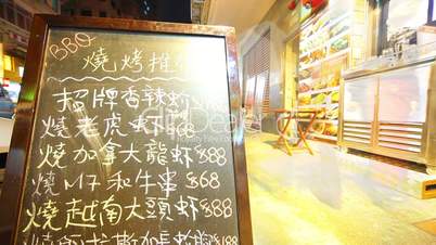 Streetside restaurant dining with blackboard menu in Hong Kong.Timelapse