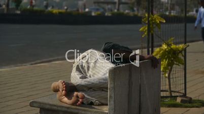 Man sleeping on a street bench