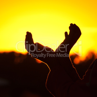 little girl holding in hands the setting sun