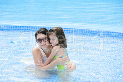 Mother and her baby having fun in the swimming pool.
