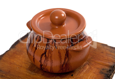 Dirty ceramic pot on old wooden kitchen board