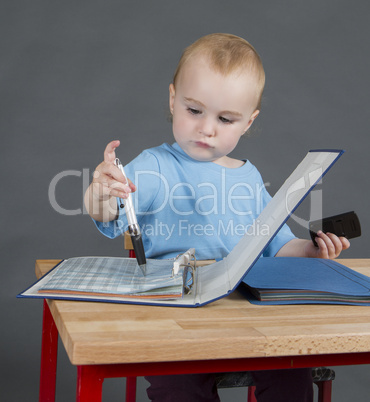 baby with paperwork at wooden desk