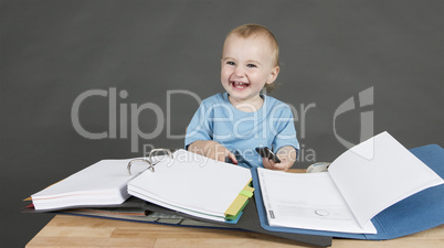 child with paperwork at desk