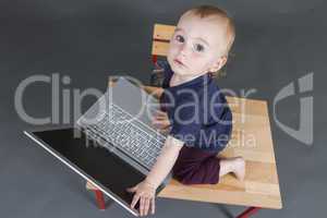 baby with laptop computer in grey background
