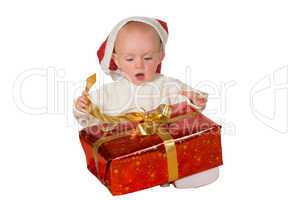 Little baby untying a Christmas gift