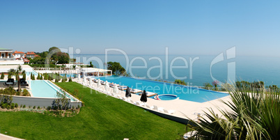 Panorama of infinity swimming pool by beach at the modern luxury