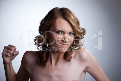 Aggressive young woman clench one's fist