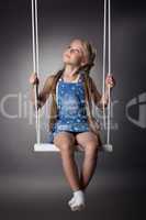 Beautiful girl sitting on swing