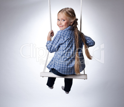 Pretty girl sitting on swing