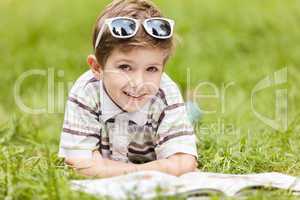 Beauty smiling child boy reading book outdoor