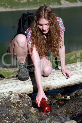 Junge Frau schöpft Wasser