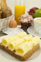 Frühstück mit toast, käse, ei und früchten auf einem Tisch